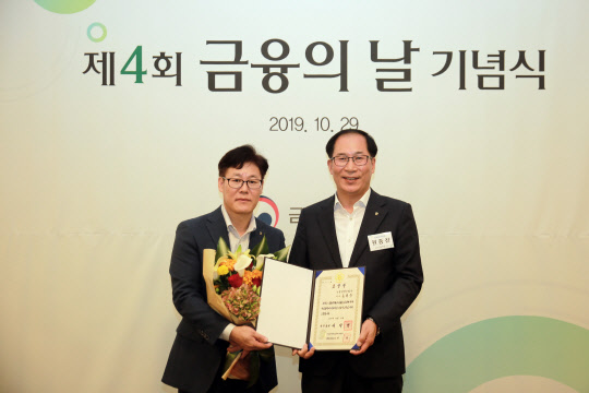 상품 개발에 공을 세운 NH농협생명 고객지원부 송원주 팀장(왼쪽)과 영업지원부문 원종찬 부문장(오른쪽)이 기념촬영을 하고 있다. NH농협생명 제공